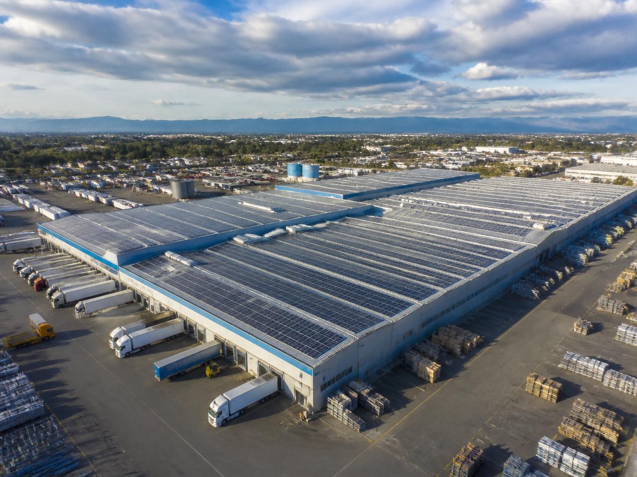 Aerial view of an industrial facility with rooftop solar panels